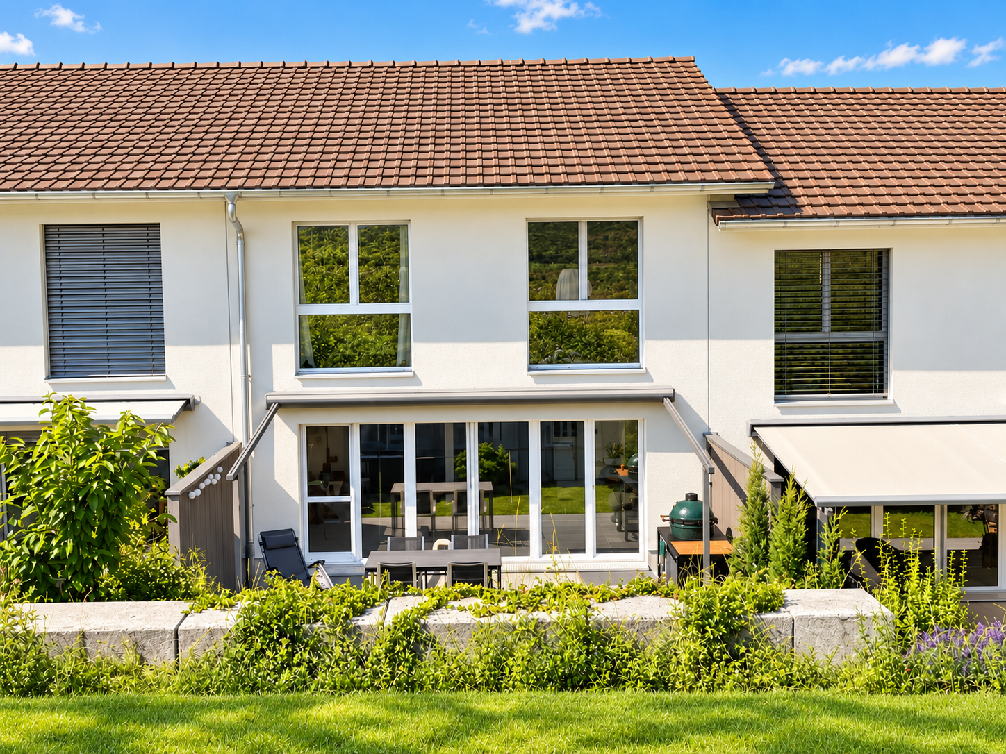 Sonnige Terrasse mit klassischem Ziegeldach und Garten